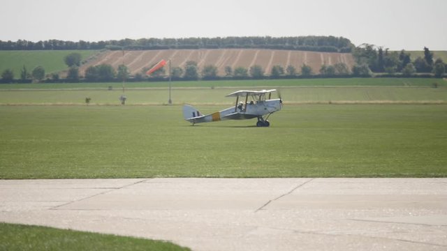 Bi Plane taxi's across grass in slow motion