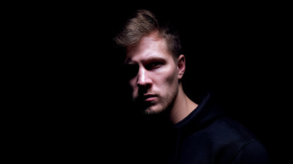 Fototapeta premium Scared bruised man standing against dark background, victim of hooligan, closeup