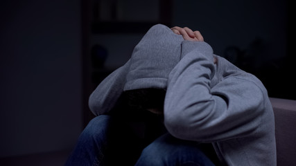 Frustrated teenager suffering parental divorce, trying to hide from problems