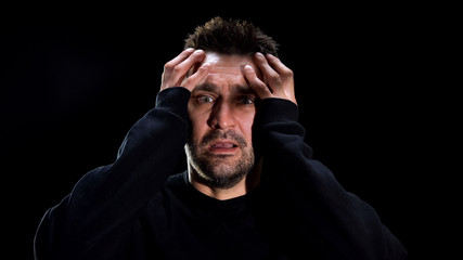 Mentally ill patient suffering hallucinations on black background, panic attack