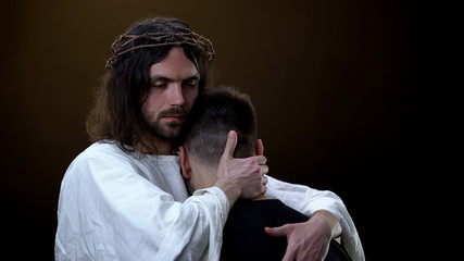 Christ hugging depressed parishioner dark background, God kindness, protection