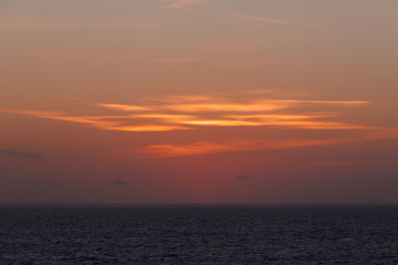 Fototapeta premium Orange sky and clouds right after sunset behind the italian coast
