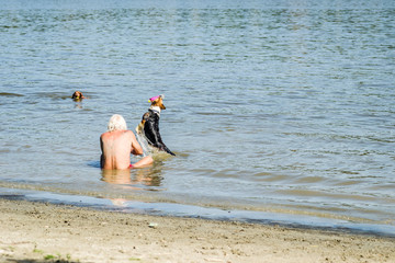 An older gentleman on the beach with your pets. The dog and its owner to bathe in the river Danube