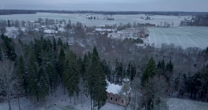 A view of the Galgauska church, left unused and abandoned in the woods. Its beautiful architecture lost to time and damage. Drone footage sweeping in and revealing the nearby town of Galgauska