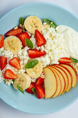 Healthy eating Dessert with cottage cheese and strawberries in a blue plate on a white tablecloth