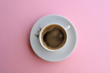 cup of coffee on light pink background