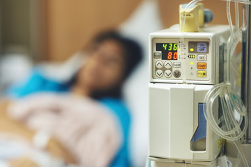 IV machine while and blurred of patient woman lying sleeping