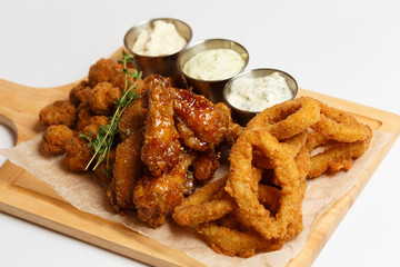 grilled wings, deep-fried squid rings, appetizers with a sauces
