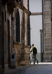 Fototapeta na wymiar Man With Bicycle Leaving Alley 