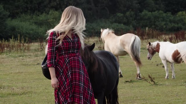 Girl at the ranch greeting horses.