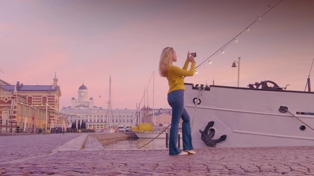 Travel Woman Uses Smartphone to Take Photos of Boats