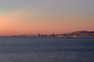 Fototapeta premium Sunset view over the bay in Izmir,ship and mountains