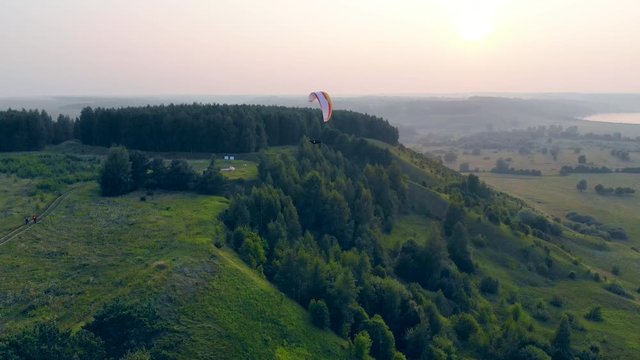 Green terrain and the paraplane flying above it