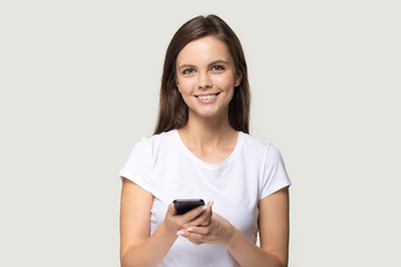 Smiling millennial girl look at camera using modern smartphone