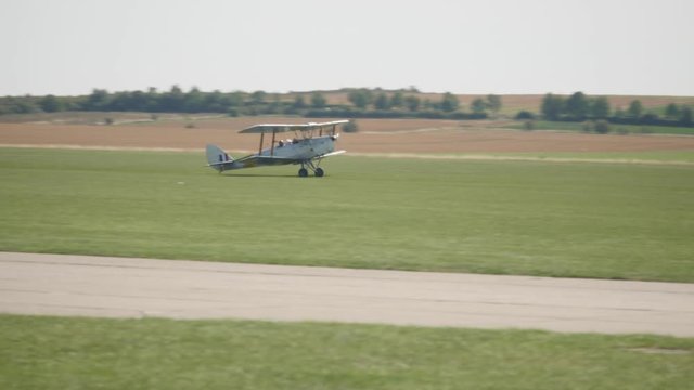 Tiger Moth Bi Plane lands on an airfield