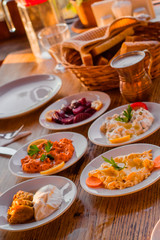 traditional turkish appetizers on table in evening sun light and ayran in a copper glass