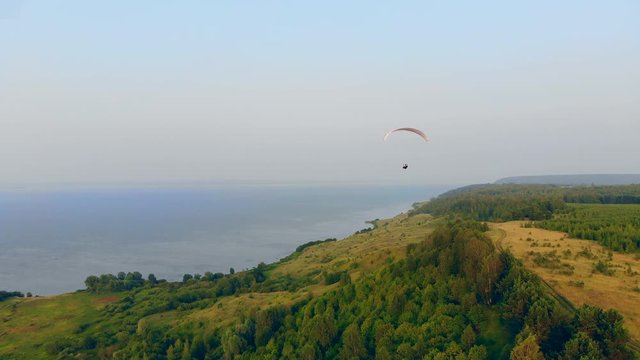 Natural scenery and the parasailing vehicle flying over it