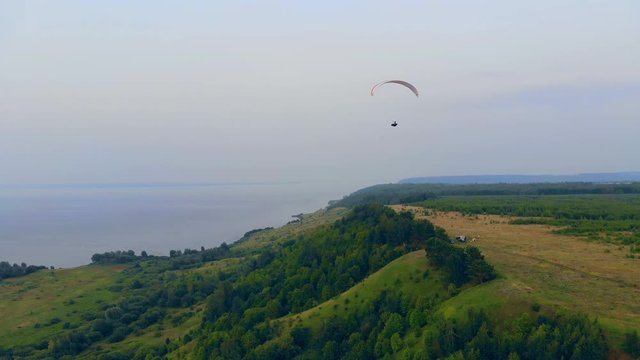 Green slopes and the parawing flying above them
