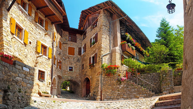 Canale di Tenno - beautiful medieval village in Italy, near the lake Lago di Garda, hisoric village in the mountains with houses with stone walls and flowers in the windows, narrow cobbled streets