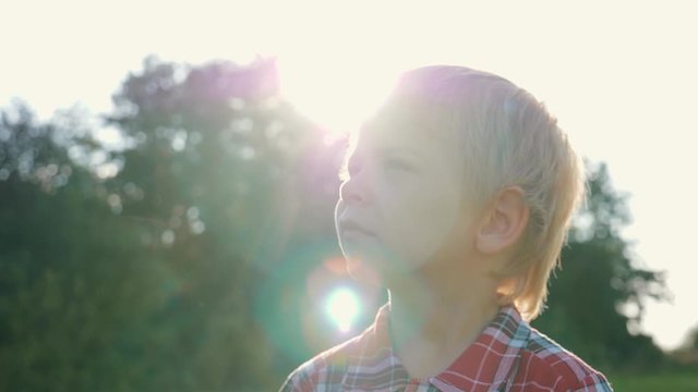 Close up face of a boy. Looking up. Childhood dreams. Fantasy and games. Boy looks at the sky