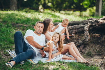 Fototapeta premium Young family with little kids in summer park on sunny day.