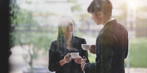 Young professional business partner having coffee break after the meeting