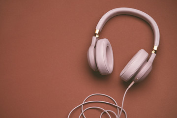 Colored headphones on a brown vintage background. Music concept with copyspace. Colored headphones isolated