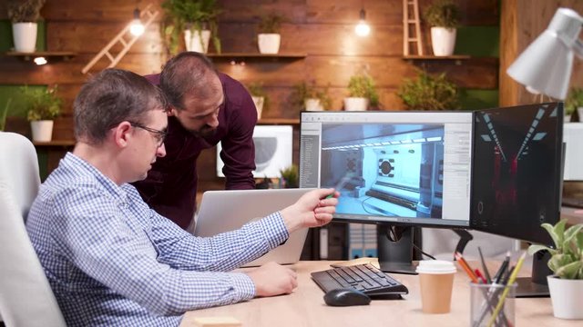 Graphic desginer working in gaming industry showing his assitant the new game design. Game developer.