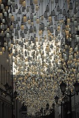 Obraz premium An alley of Moscow with lanterns standing and fortified on the walls of houses and yellow and white bulbs hanging in the sky.