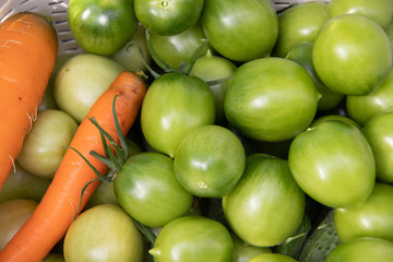 Green tomatoes in a basket. Ripening vegetables. Harvesting. Healthy food.