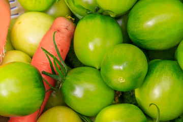 Green tomatoes in a basket. Ripening vegetables. Harvesting. Healthy food.