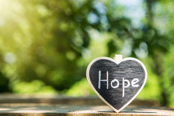 Hope - inscription on the heart, sharing hope concept, green bokeh background