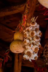 Dry vegetables hang under a wooden ceiling