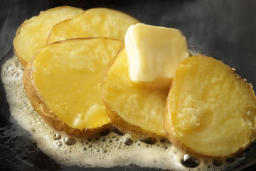 湯気の立つホクホクのジャガイモのバター焼き