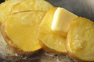 湯気の立つホクホクのジャガイモのバター焼き