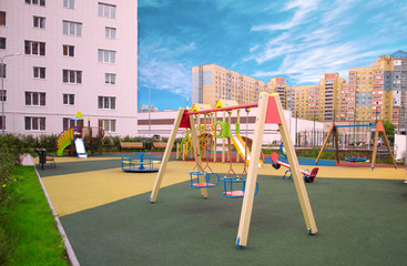 Fototapeta na wymiar Large multi-colored Playground with different attractions in the courtyard of an apartment building