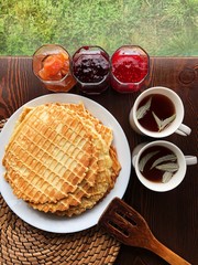 Delicious fresh waffles and jam on the table