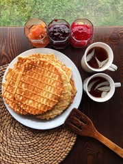 Delicious fresh waffles and jam on the table