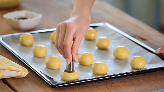 Woman making shortbread cookies in form of mushrooms.