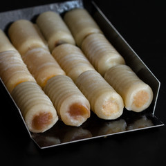 Huesos de Santo or Bones of the Saints on black background. The most traditional of Spanish mazapan sweets eaten on All Saints Day or Dia de todos los Santos.