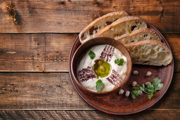 Khumus with bread on a clay plate