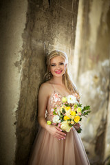 happy bride in pink dress with flowers