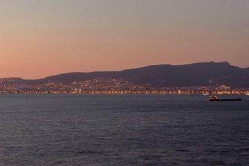 Obraz premium Sunset view over the bay in Izmir,ship and mountains