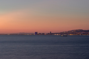 Fototapeta premium Sunset view over the bay in Izmir,ship and mountains