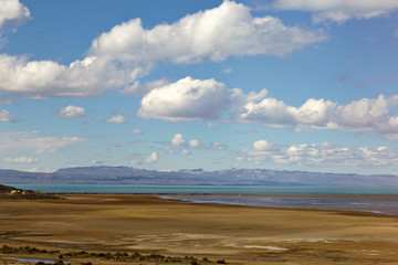 Argentina Patagonia, Calafate region. Beautiul blue sky with white clouds, Plains with a lake and blue mountains in the horizon