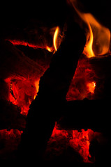 Actively smoldering embers of fire. Background of burning hot coals. Flicker of burning coals at...