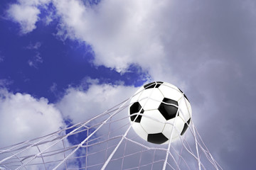 Fototapeta na wymiar Goal. Soccer ball in net with sky background.