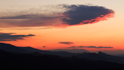 Passing cloud body above the mountains right after sunset.
