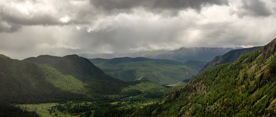 panorama of mountains with a forest in the Altai region in the last rays of the sun, Russia