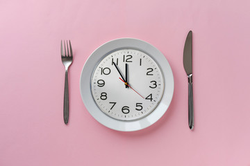 Pink table setting with clock on a plate